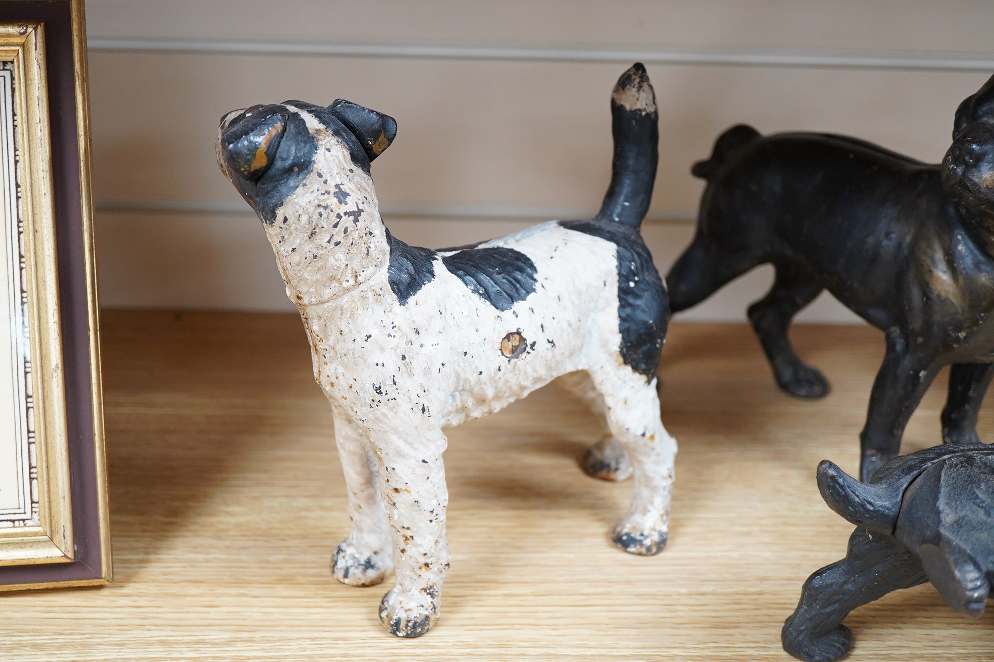 A group of three painted metal dogs, largest 25cm high x 23cm wide